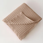 Two extra large brown waffle weave towels folded neatly