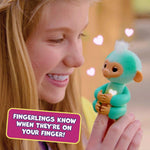 Fingerlings Ava teal robotic monkey toy on a child's finger