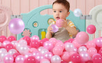 Toddler holding a 2.2 inch Guesvot plastic play ball