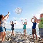 A group of people playing with the 16 inch Hsei silver glitter balls in a swimming pool.