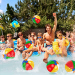 Group of children playing with multiple inflatable water toys during a Hawaiian tropical themed birthday party