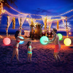 Adults and teens playing a night volleyball game with a glowing sixteen inch ball.