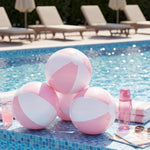 A group of people tossing a 16 inch MiniInflat pastel pink decorated ball at a summer birthday celebration.