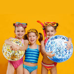 Adults and children tossing the jumbo sparkling clear pool balls during an outdoor summer party