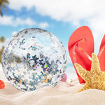 Sparkly silver confetti beach balls floating in a swimming pool