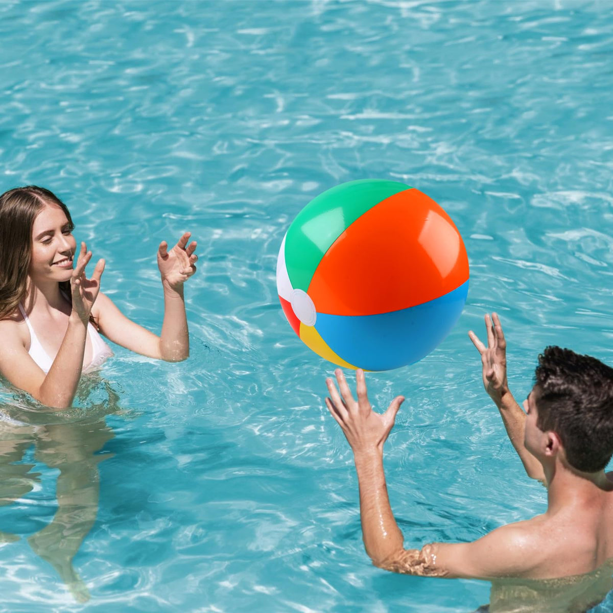 Kids and family playing with large rainbow colored inflatable accessories during an outdoor summer party.
