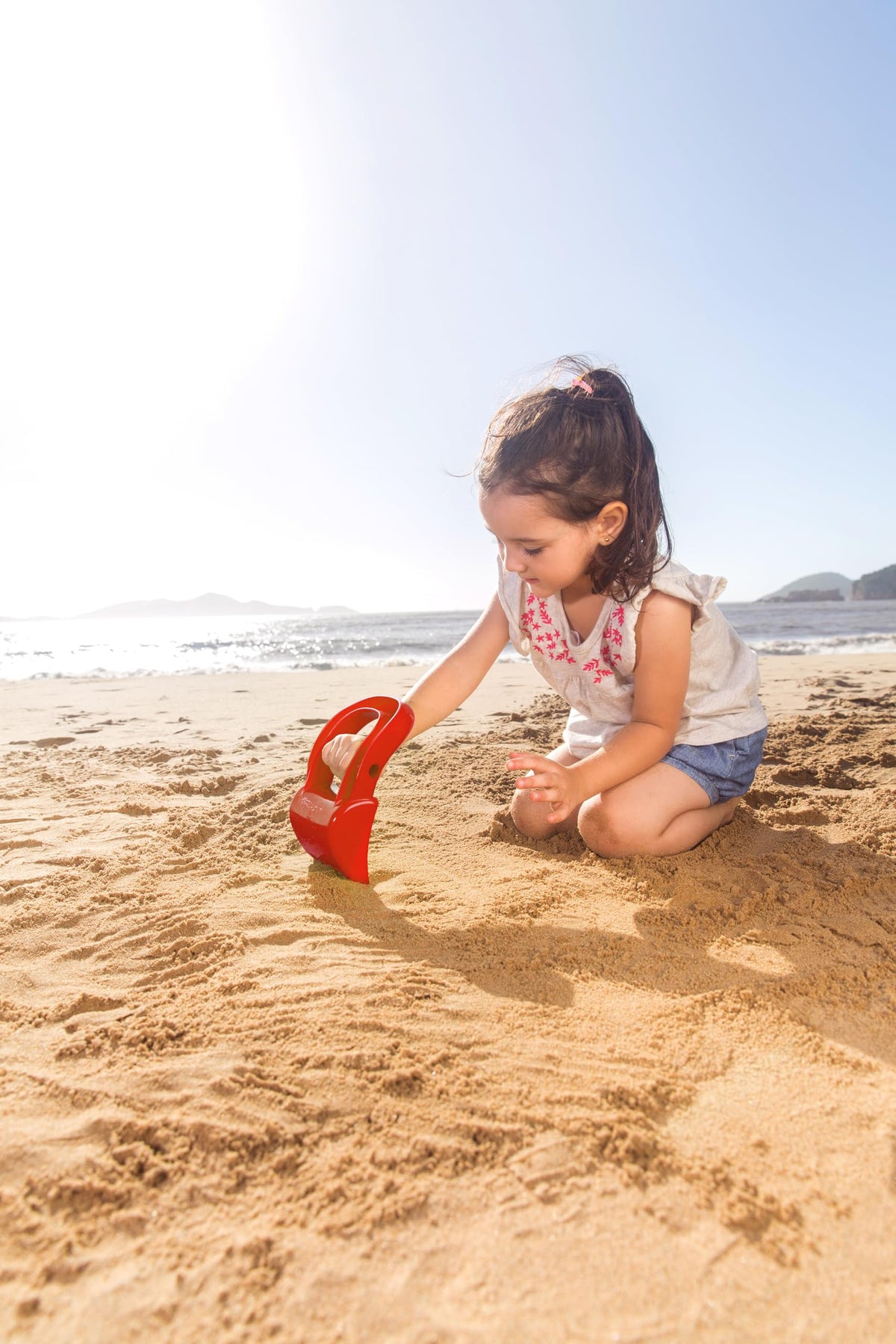 Durable red plastic hand shovel for beach play