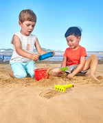 Toddler playing with Hape beach bucket and shovel set