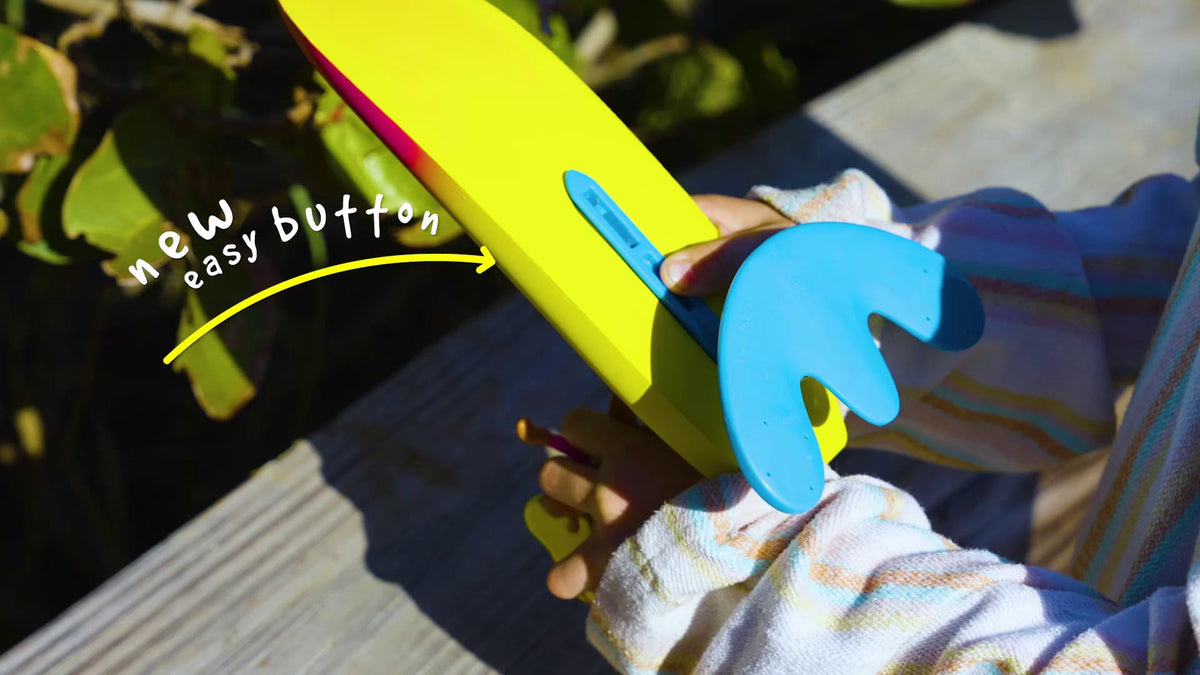 Child playing with Surfer Dudes beach toy at the shore