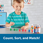 Six different colors of plastic teddy bear counters spread out on a white background