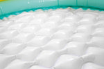 Portable backyard baby bath tub deflated and folded next to packaging.