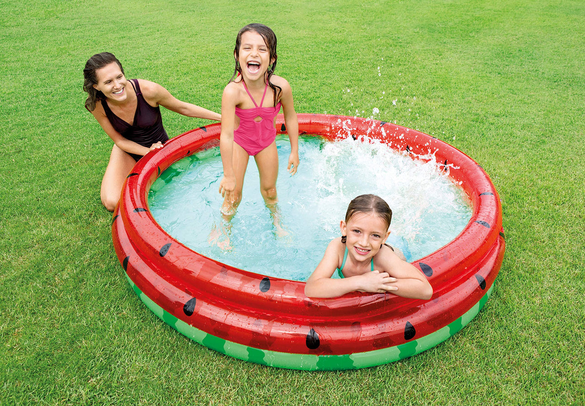 Intex watermelon splash pool being inflated with an air pump outdoors.
