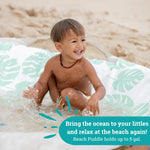 Toddler playing safely inside the excavated Beach Puddle flexible beach pool liner.