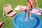 Portable three ring circular water splash pool for children inflated on an outdoor concrete patio surface.