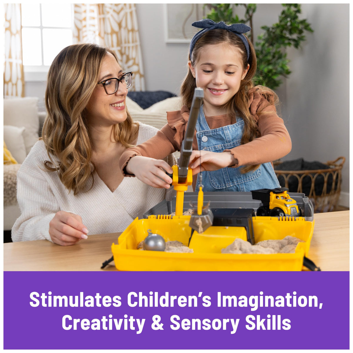 Child playing with Kinetic Sand construction site and sensory tools.
