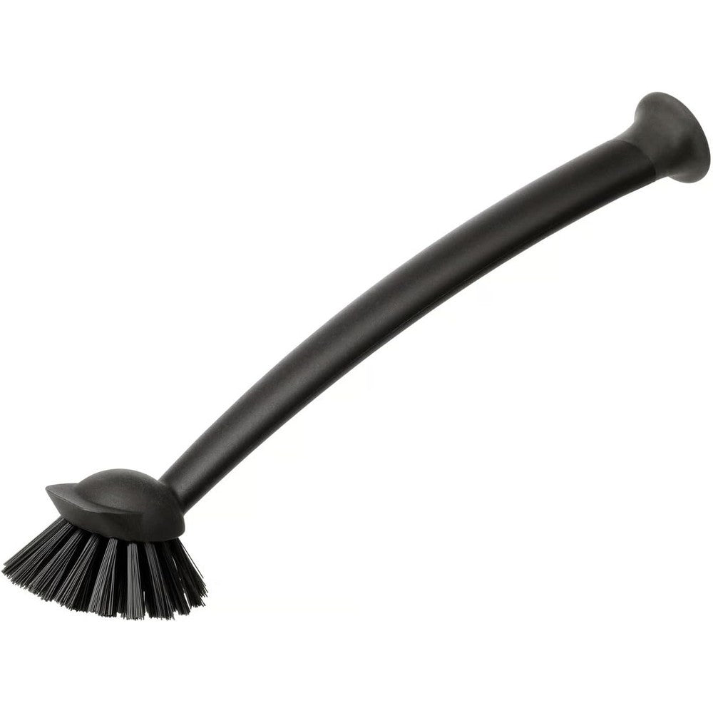 Ikea Rinnig dish-washing brush black with suction cup standing on a sink.