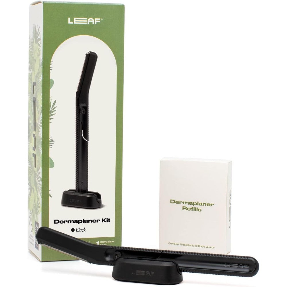 Leaf Shave Leaf Dermaplaner Kit in black featuring the all metal reusable facial razor resting on its matching weighted stand
