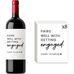 Gejoyse 8 Pieces Engagement Wine Bottle Labels front view showing Pairs Well text on a standard bottle.