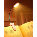 Monotremp rechargeable book light front view clipped onto a paperback book at night.