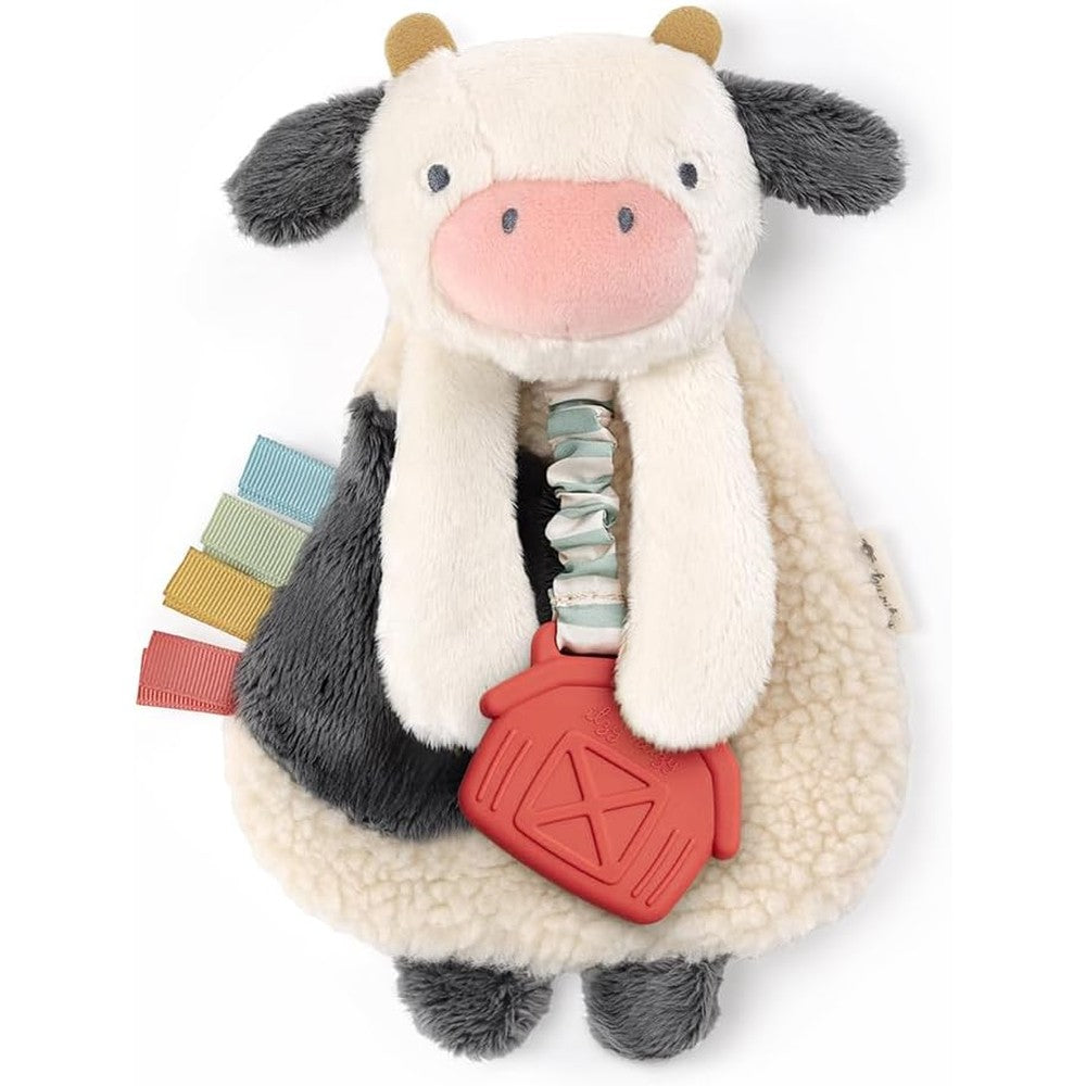 Itzy Ritzy Itzy Lovey cow plush teether front view showing the soft sherpa fabric and attached red silicone teething ring.