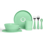 Ubbi Toddler Feeding Set 7 Piece front view showing green plate bowl cup and utensils with suction base