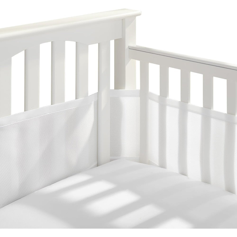 BreathableBaby classic mesh crib liner front view installed on a white wooden full-size baby crib