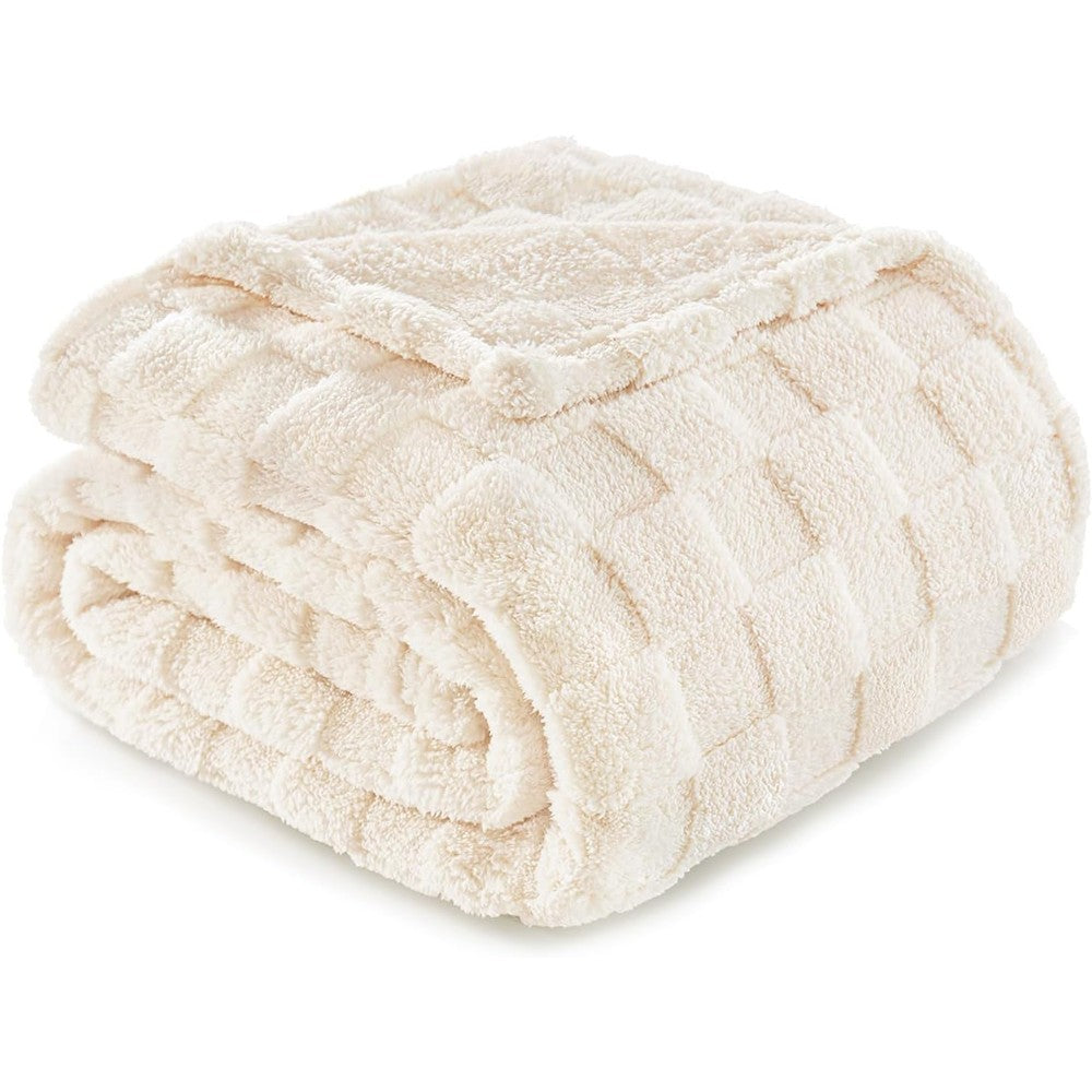 Exclusivo Mezcla ivory fleece throw blanket draped on a couch