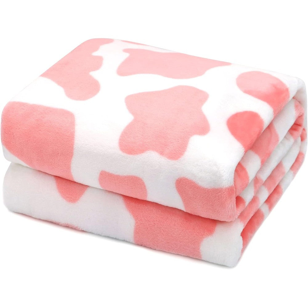 HSEEC pink cow print throw blanket front view displayed neatly on a modern couch.