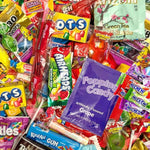 A dense pile of assorted candy and sweet treats, including Skittles, OTS, Popping Candy, Root Beer, and Harney & Sons, filling the frame.