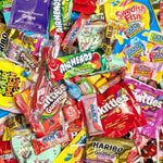 A dense, colorful assortment of packaged candies and sweets filling the frame, including Skittles, Haribo, Airheads, Jolly Jolly, and Popping Candy.